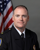 Police Chief Edward Kinney in uniform with flag in background